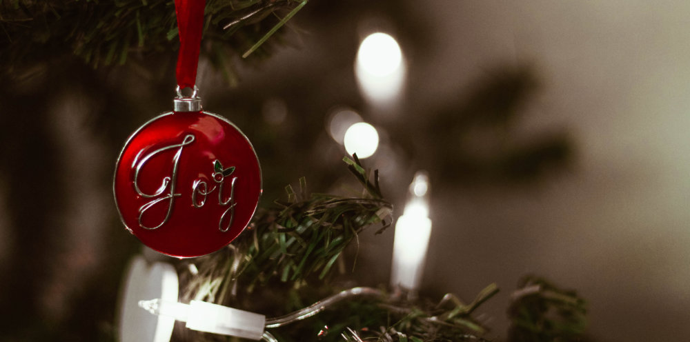 Christmas ornament hanging from a tree that says Joy