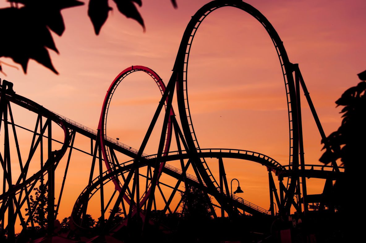 silhouette of a roller coaster at sunset during a fun fair