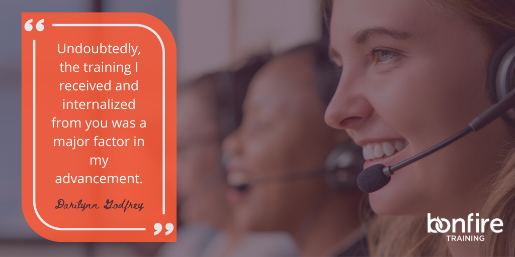 A woman wearing a headset smiles joyfully in a call center. Text reads: “Undoubtedly, the training I received and internalized from you was a major factor in my advancement. Darilynn Godfrey.” Logo: Bonfire Training.