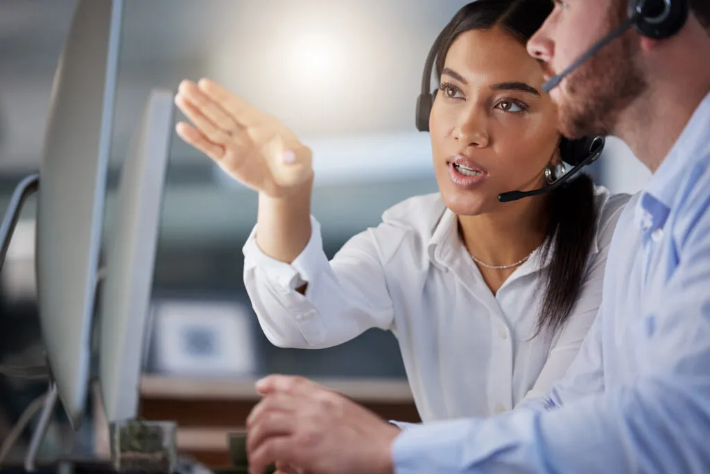 Customer service coach guiding team member during call center training
